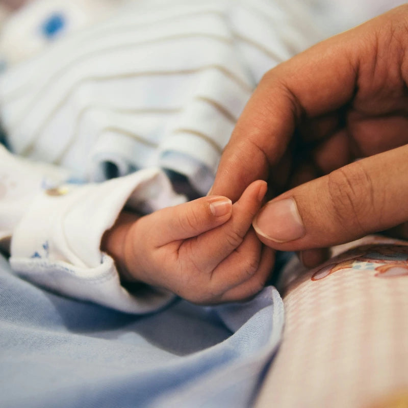 petite main de bebe sur coussin d'allaitement